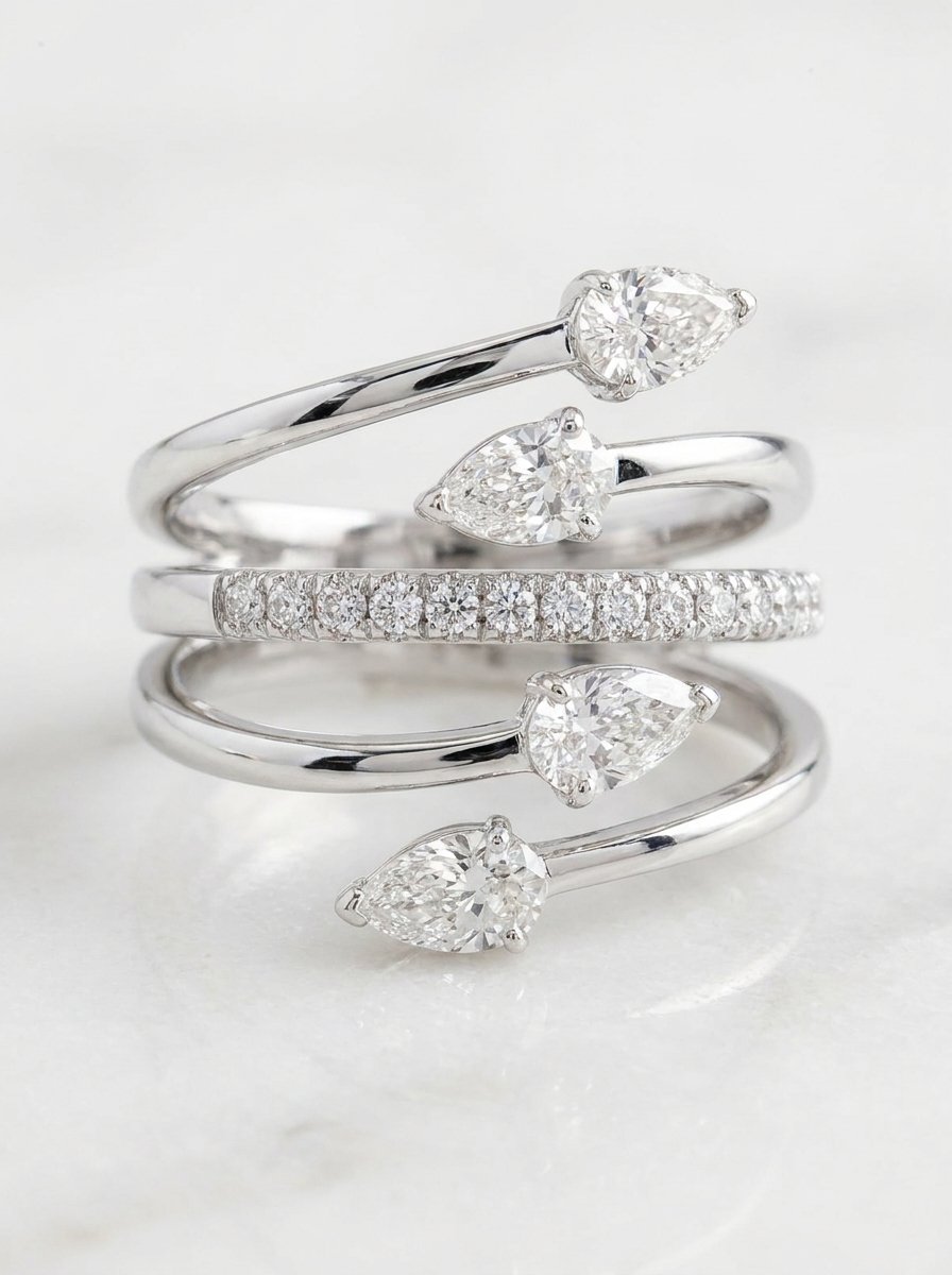 Anello fantasia in oro bianco con 4 diamanti bianchi taglio goccia per un totale di ct. 0,95 F-SI e mezzo giro di diamanti bianchi sulla fascetta centrale per un totale di ct. 0,13 F-VS. Au gr 6,6