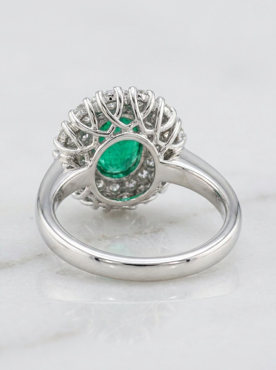 Anello contorno in oro bianco con smeraldo taglio ovale centrale ct. 1 e doppio giro di diamanti bianchi taglio brillante rotondo per un totale di ct. 1,24 G-VVS1